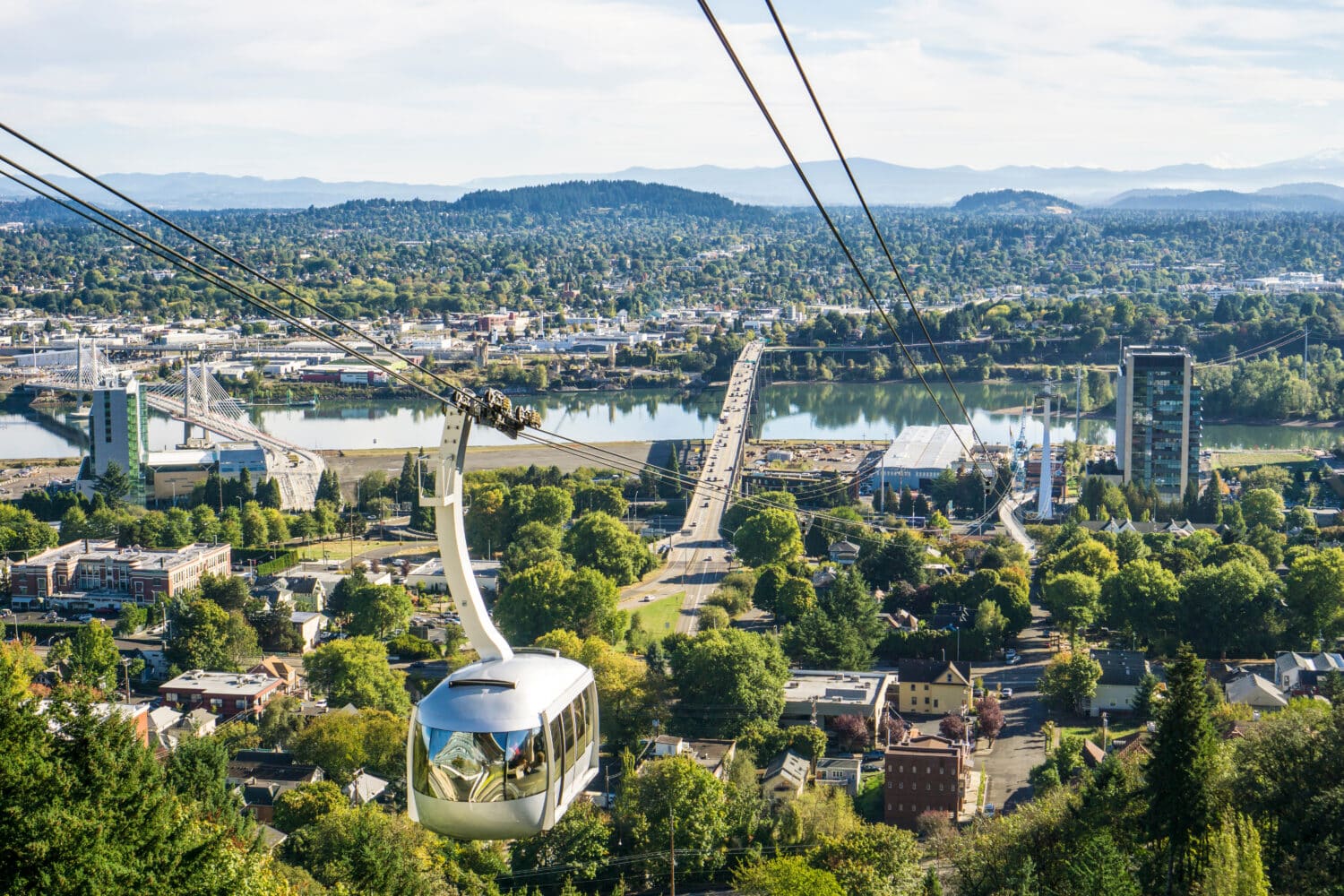 The ariel tram makes its way from campus to the city's waterfront below. Snow-capped Mount Hood can be seen in the distance.